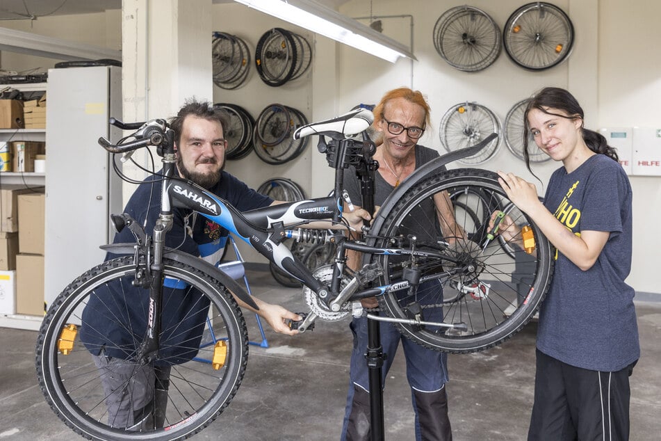 Die Schüler Jason Jentzsch (18) und Amely Schuster (16) tüfteln mit Ausbilder Reiner Richter (64) an einem Fahrrad.