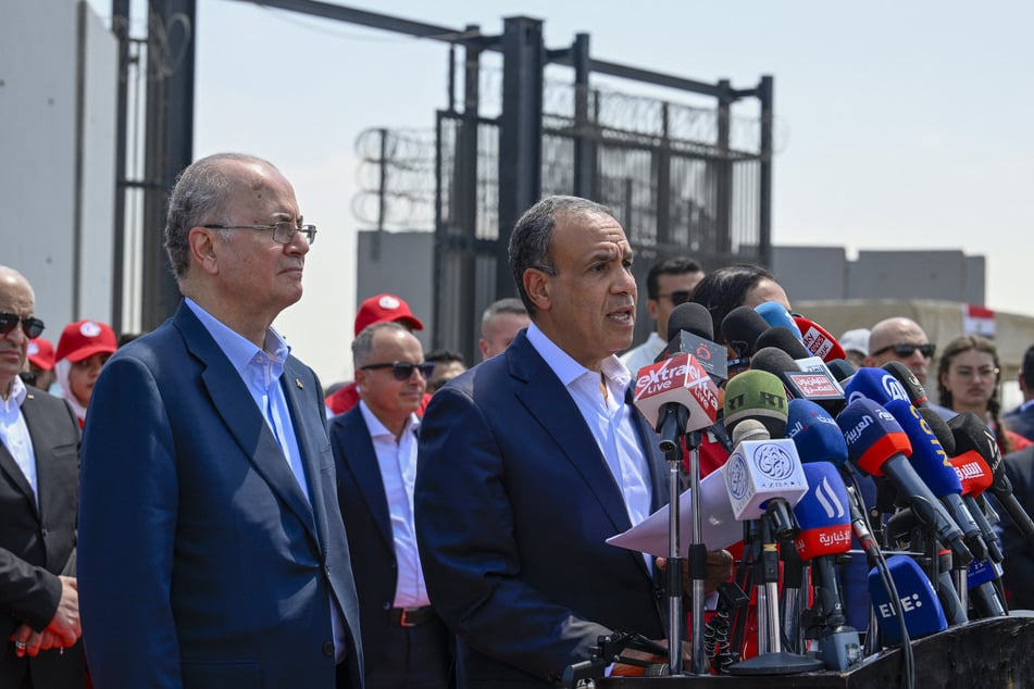 Palestinian prime minister Mohammad Mustafa (l.) listens as Egypt's Foreign Minister Badr Abdelatty (c.) speaks at a press conference on the Egyptian side of the Rafah border crossing on August 18, 2025.