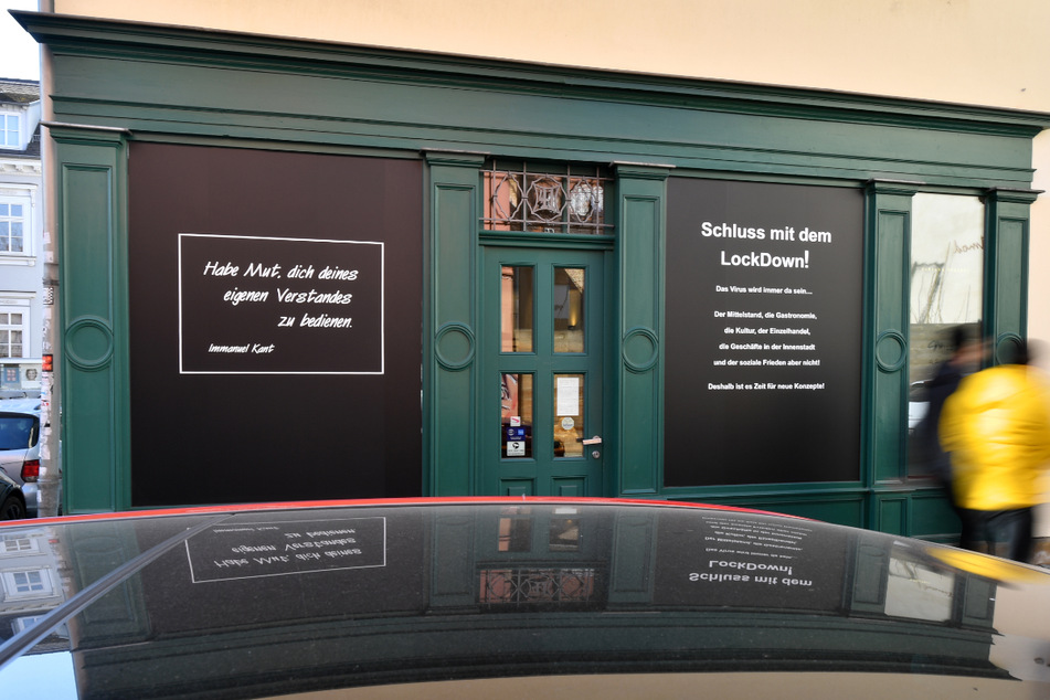 "Schluss mit dem Lockdown!" steht auf dem Plakat an einem Schaufenster in der Erfurter Altstadt. Wegen der hohen Inzidenz will das kleine Bundesland vorsichtig lockern.