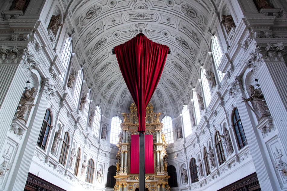Ein rotes Tuch verhüllt in der Münchner St. Michael Kirche das Kreuz vor dem Altar.
