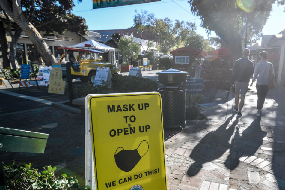 Laguna Beach: Ein Schild weist Besucher der Forest Avenue in Kalifornien darauf hin, eine Maske zu tragen. Kalifornien führt wegen steigender Corona-Zahlen wieder härtere Maßnahmen im Kampf gegen die Pandemie ein.