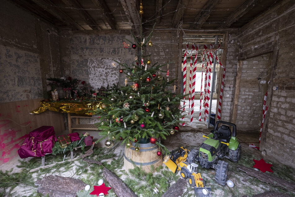 Der Bäckermeister Wido Ockenfels hat ein Zimmer seines bei der Ahrflut 2021 zerstörten Hauses in Mayschoß mit einem Weihnachtsbaum, Lichterketten und Kinderspielzeug dekoriert.