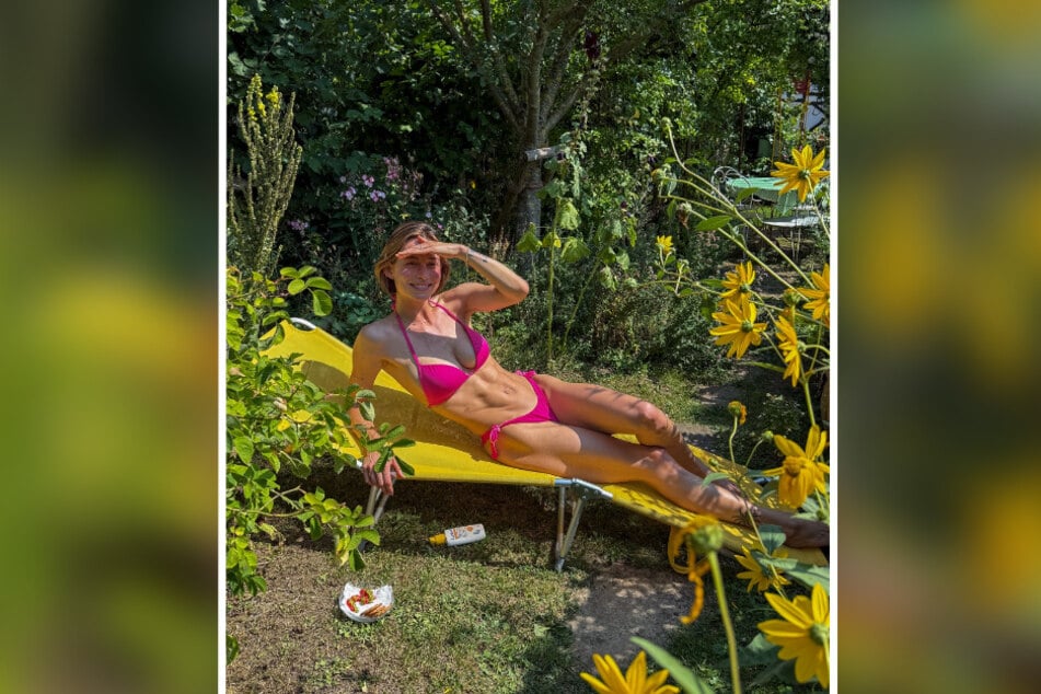 Im pinken Bikini und mit gestähltem Waschbrettbauch macht es sich Jennifer Lange im Garten bequem.