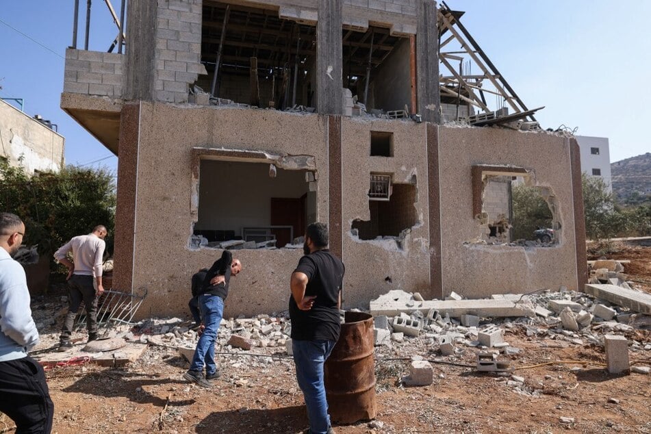 People inspect a damaged building where a Palestinian man was reportedly killed during an Israeli army raid in Tammun village south of Tubas in the occupied West Bank on November 5, 2024.