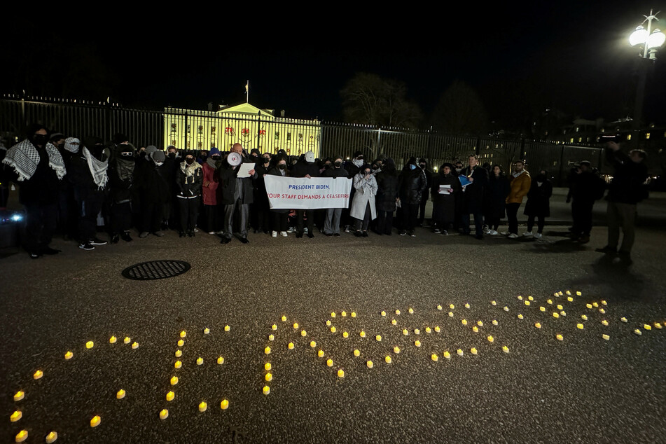 Biden administration staffers spell "Ceasefire" with candles during their vigil outside the White House.