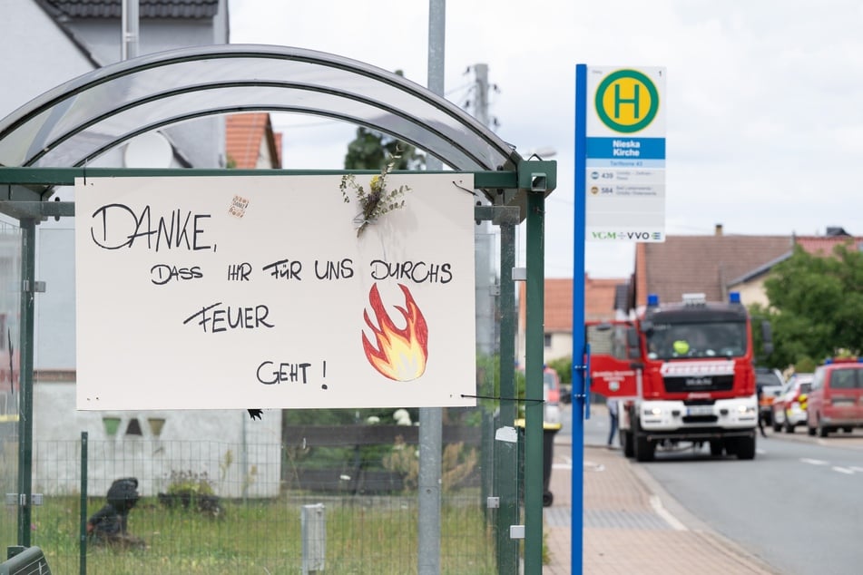 Ein Schild mit der Aufschrift „Danke, dass ihr für uns durchs Feuer geht“ hängt während des Waldbrands in der Gohrischheide an einer Haltestelle in Nieska.