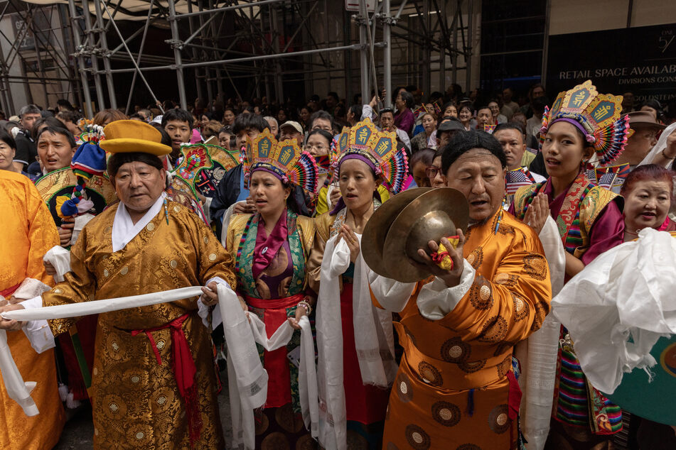 Performers and members of the Tibetan community wait outside a hotel where spiritual leader, the Dalai Lama, will stay in New York City.