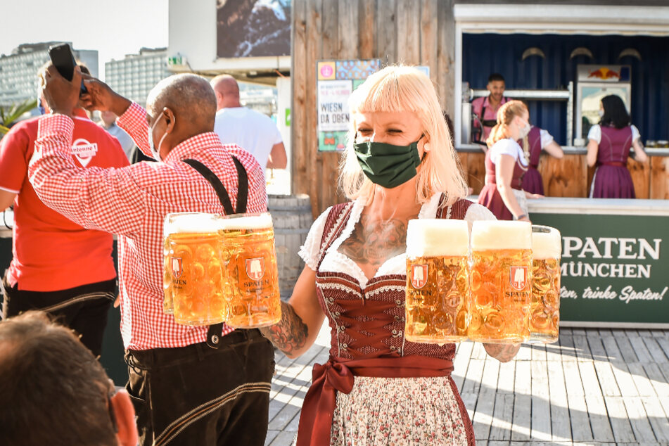 Eine Bedienung trägt Biergläser bei einer Festveranstaltung mit dem Titel "Wiesn da oben".