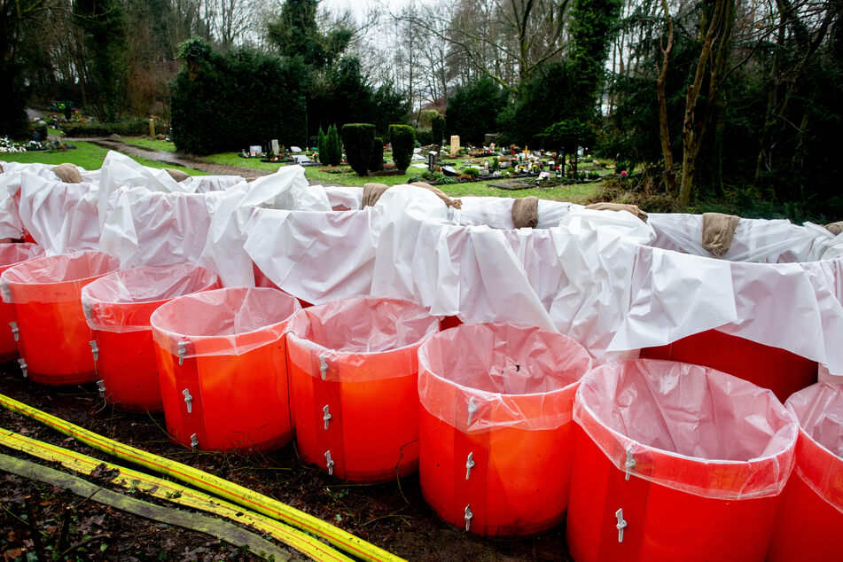 Ein mobiles Deichsystem, bestehend aus zahlreichen mit Wasser gefüllten Behältern, steht auf dem Parkfriedhof Bümmerstede.