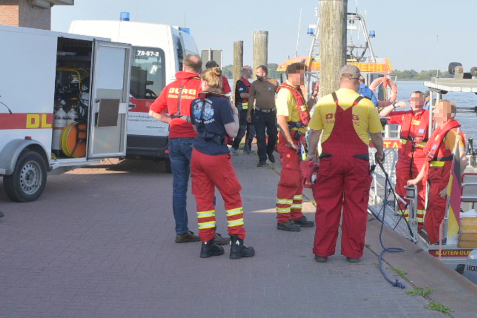 Einsatzkräfte der DLRG am Anleger Stadersand. Aktuell wird nach einem Mann gesucht, der in die Elbe stürzte.