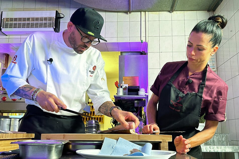 Andi Schweiger zeigt Susan ein paar Kniffe in der Küche.