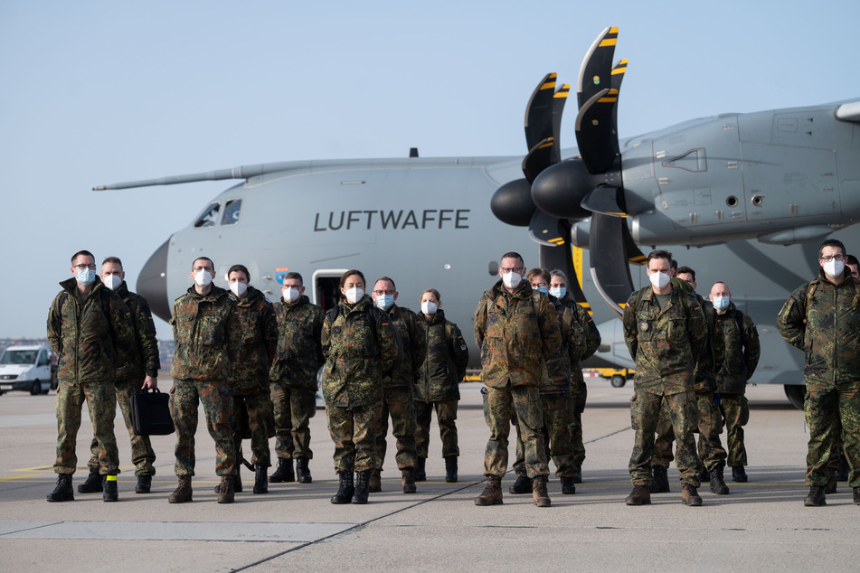 Angehörige des Sanitätsregiments 3 der Bundeswehr aus Dornstadt stehen am Flughafen Stuttgart vor einem Airbus 400M der Luftwaffe.