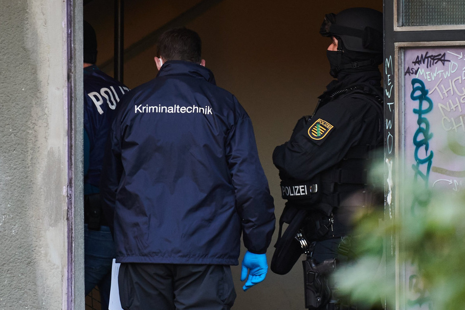 Polizei und Kriminaltechniker am Eingang eines Wohnhauses in Berlin.