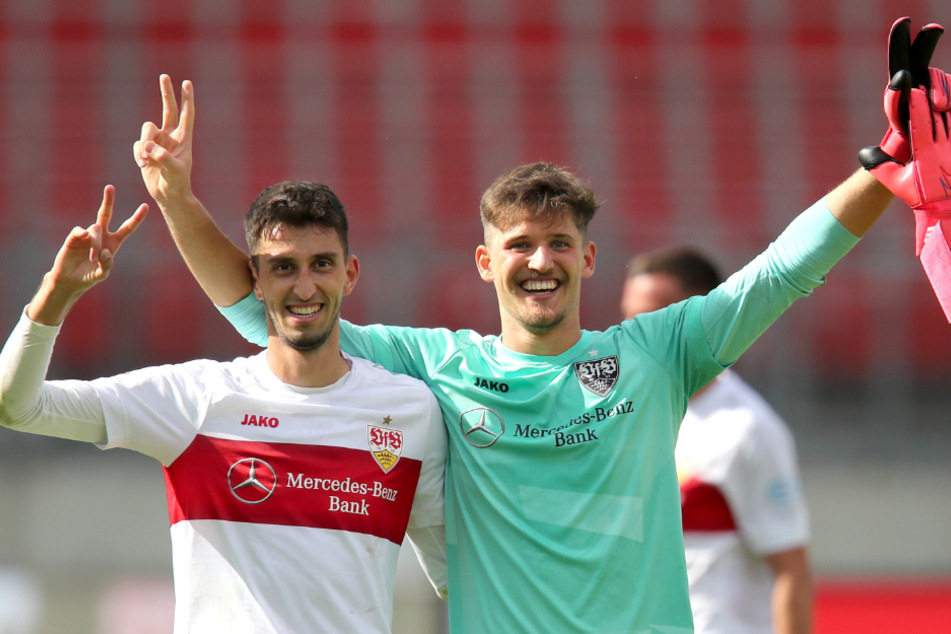 Die VfB-Profis Atakan Karazor (23, links) und Gregor Kobel (22) stehen jubelnd nach dem Abpfiff auf dem Platz.