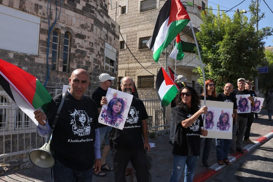 Activists lift Palestinian flags and placards depicting slain Palestinian-American journalist Shireen Abu Akleh during a rally near Augusta Victoria Hospital in east Jerusalem during Biden's visit to the facility in July 2022.