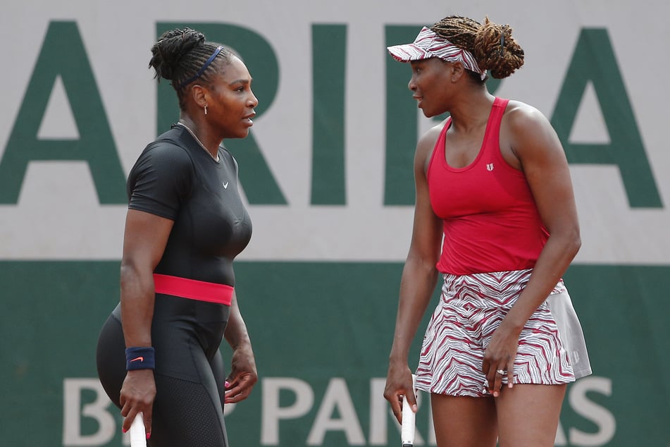 Venus (r) und Serena Williams besprechen ihre Taktik vor dem Spiel.