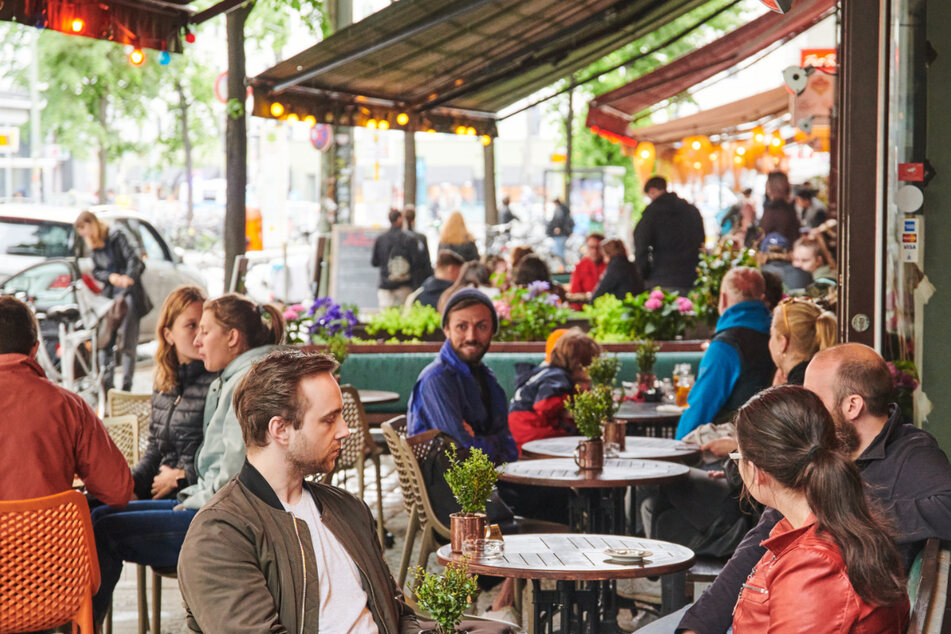 Viele Gäste sitzen zur Mittagszeit in Restaurants und Cafés im Berliner Weinbergsweg.