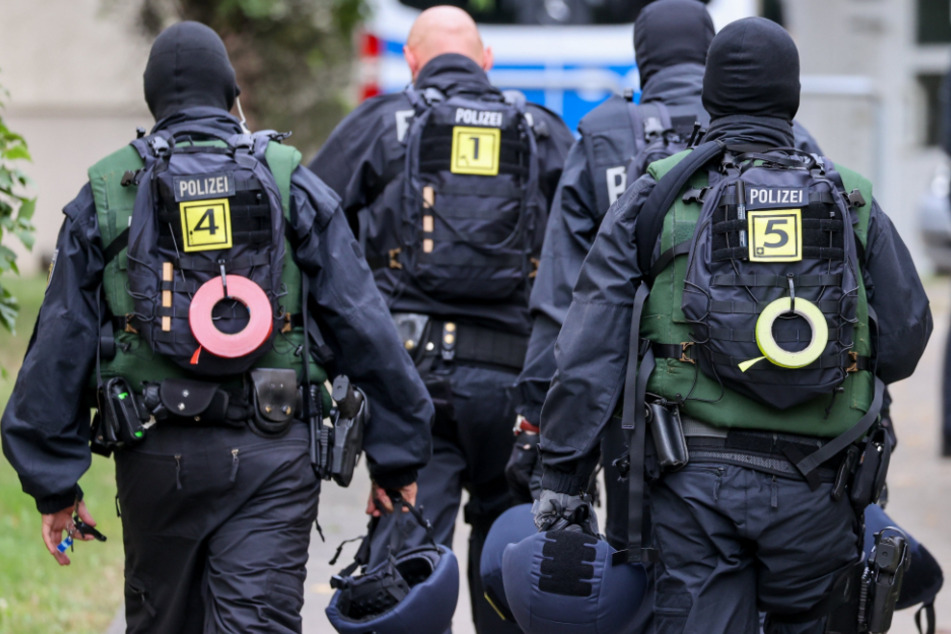 Beamte der Bundespolizei gehen im Rahmen einer Razzia durch ein Wohngebiet.