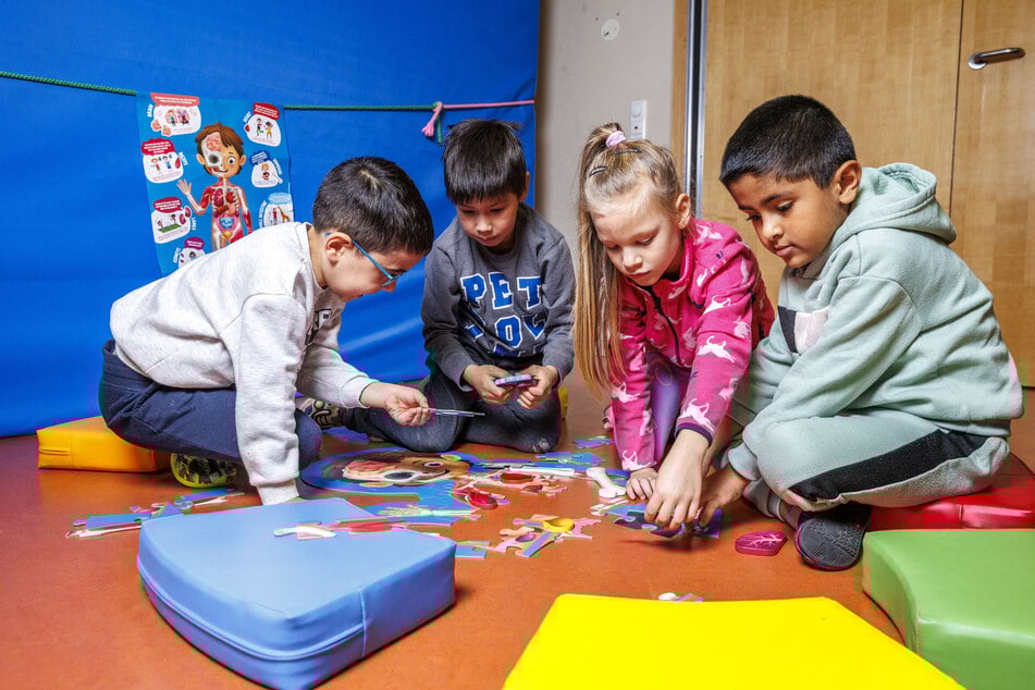 Die Spatzennest-Vorschüler Roer (6), Hung Lee (6), Helena (6) und Mohammad (7) aus Prohlis spielen gerne mit den Materialien aus der "Schatzkiste".