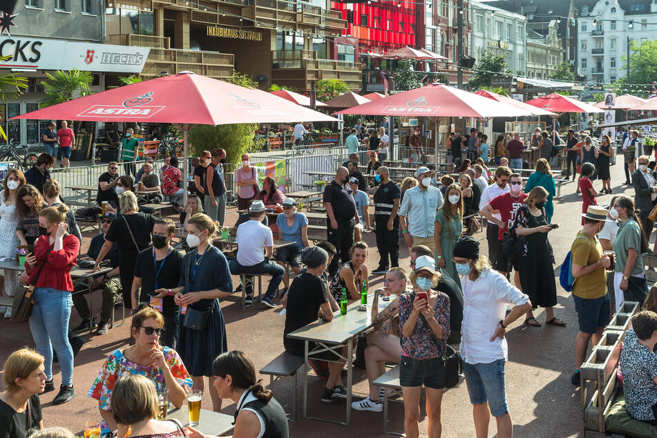 Besucher genießen die Angebote der Außengastronomie auf dem Spielbudenplatz.