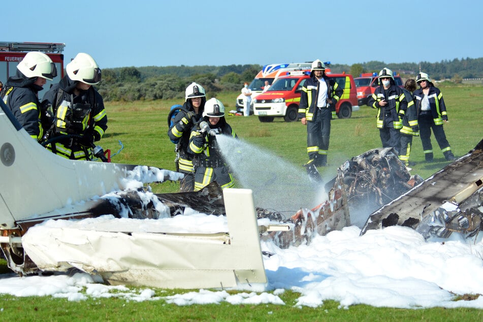 Borkum: Feuerwehrleute löschen das in Brand geratene Flugzeug.