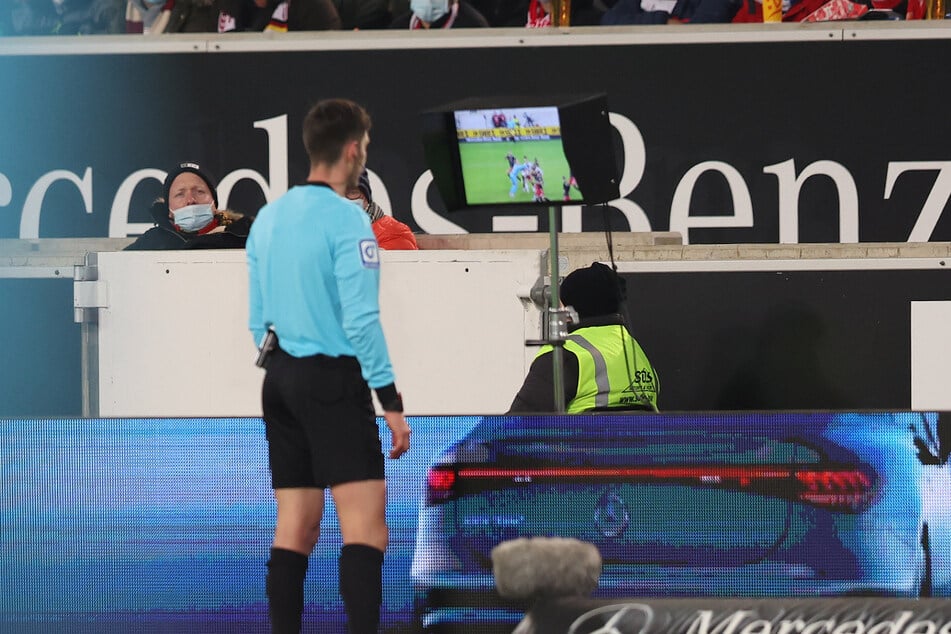 Schiedsrichter Matthias Jöllenbeck schaut sich die strittige Szene nochmal an.