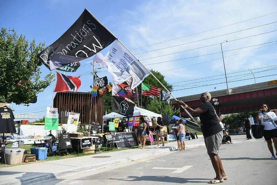 A woman in Tulsa, Oklahoma, waves a flag calling for reparations on Juneteenth 2021.