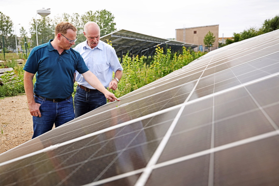 Zeithains Bürgermeister Mirko Pollmer (l.) und Rutger Kretzschmer von SachsenEnergie begutachten die neue PV-Anlage.