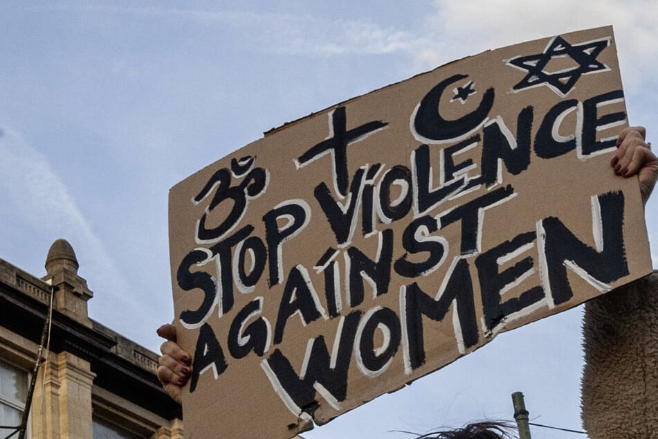 Protesters raise signs as they march in the Belgian capital of Brussels against violence against women in November 2024.