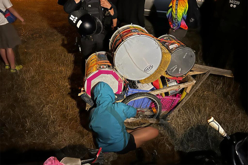 Eine Aktivistin hielt sich an den Trommeln fest, wurde später durch die Beamten entfernt.