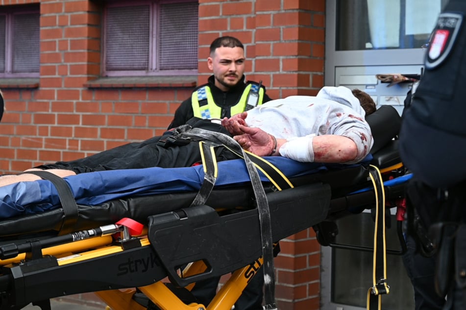 Nachdem er einem Rettungssanitäter ins Gesicht geschlagen hatte, wurde der Mann auf einer Trage fixiert. Sein Pullover wies mehrere Blutflecken auf.