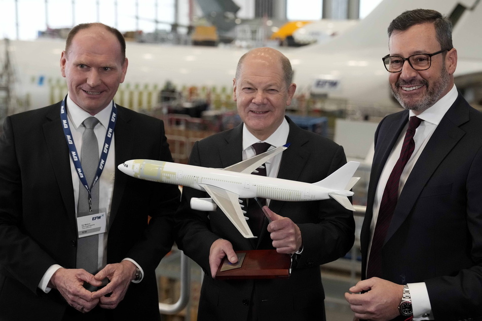 Beim Flugzeugumrüster EFW läuft's: Scholz mit den Geschäftsführern Jordi Boto (r.) und Kai Mielenz (l.) - und einem Modell des Airbus A330.