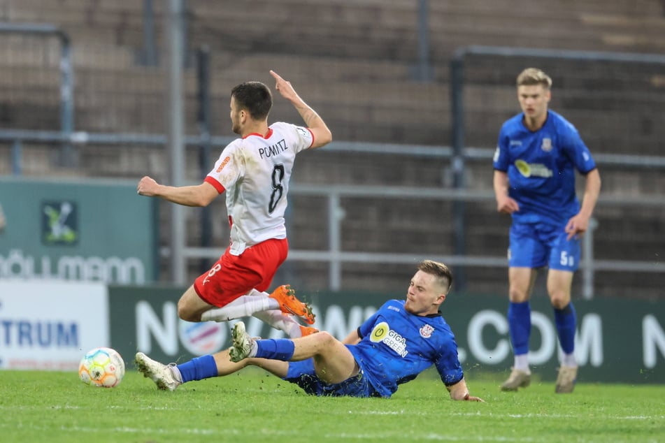 Von Dunkelblau zu Himmelblau: Manuel Reutter (21, am Boden) grätschte im Trikot des FSV Frankfurt Leon Pomnitz (28, SG Barockstadt Fulda-Lehnerz) den Ball vom Fuß.