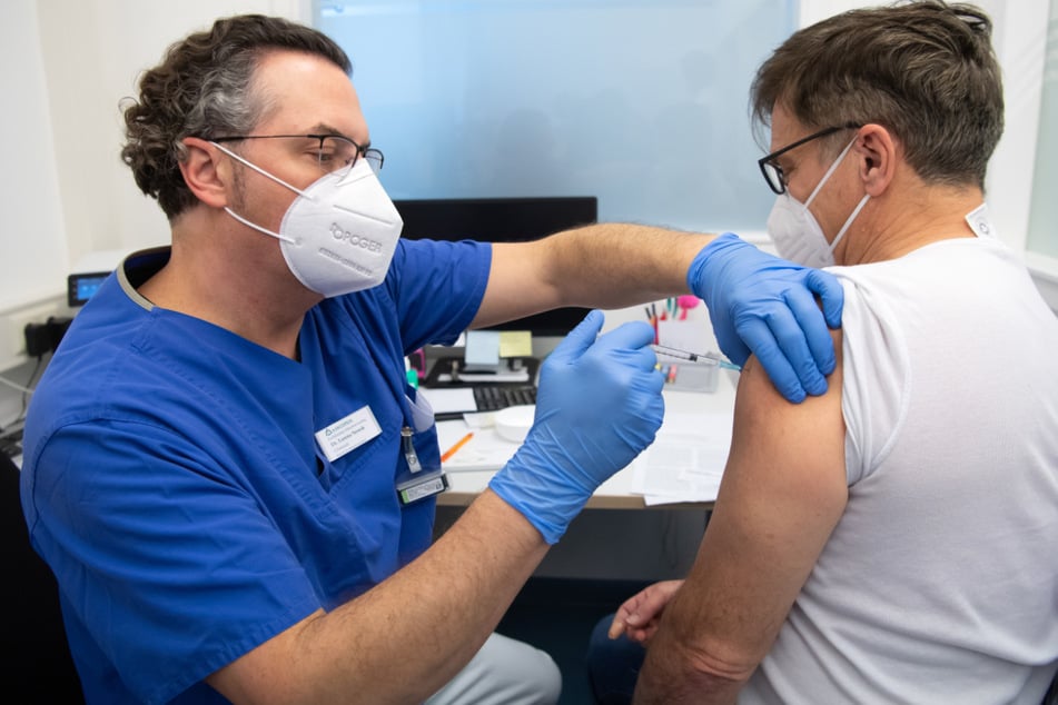 Ein Arzt der Asklepios Klinik impft einen Kollegen gegen das Coronavirus. Die Impfquote an Bayerns Kliniken liegt laut Krankenhausgesellschaft mittlerweile über 90 Prozent.