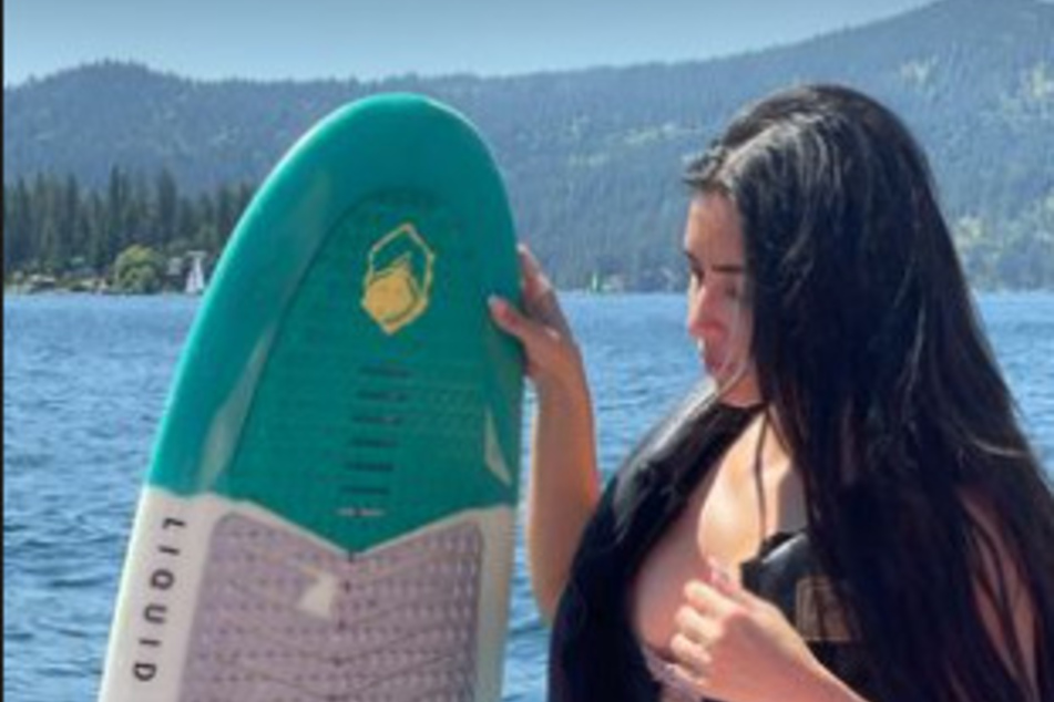 Kim Kardashian poses with her board while on vacation.