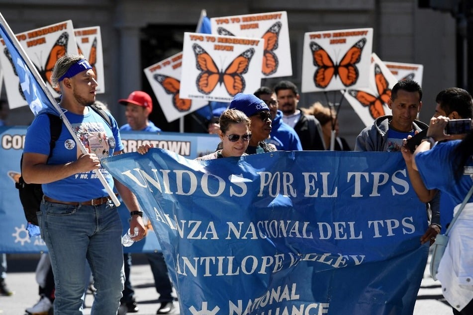 TPS holders from Central America and their families march for residency protections near the White House.
