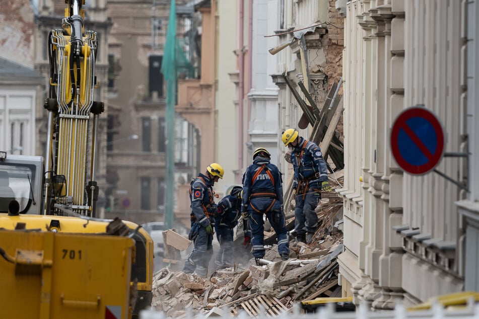 Einsatzkräfte des Technischen Hilfswerk (THW) arbeiten auf dem eingestürzten Wohnhaus.