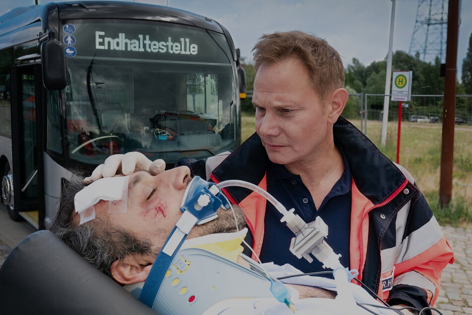 Der Busfahrer Sedat Yilmaz (Majid Bakhtiari, l.) wurde bewusstlos neben seinem Bus liegend aufgefunden. Dr. Haase (Fabian Harloff, r.) vermutet, dass ihm die Verletzungen zugefügt wurden.