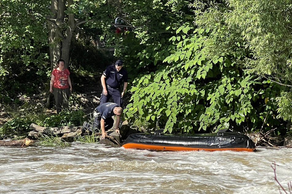 Polnische Polizisten untersuchen das gekenterte Schlauchboot auf der Neiße.