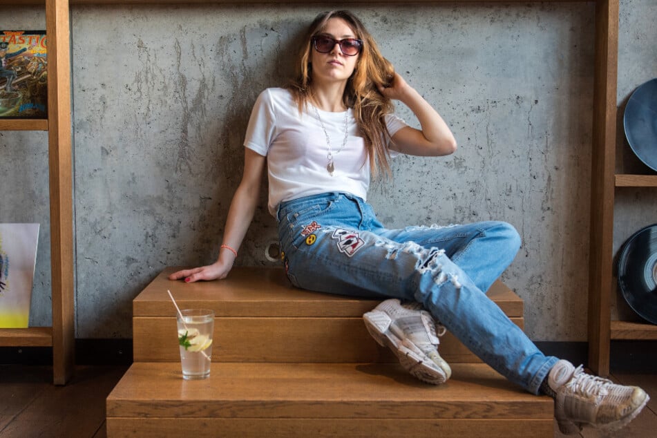 Die Rapperin Haiyti (27, Ronja Zschoche) sitzt auf einem Treppenpodest.