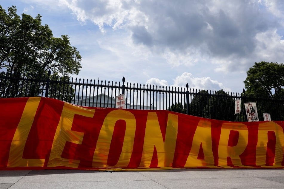 Indigenous activists hold up a banner urging President Joe Biden to grant Leonard Peltier clemency outside of the White House in Washington DC.