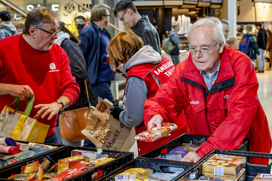 Mitarbeiter der Hamburger Tafel sortieren im Einkaufszentrum Europa Passage gespendete Lebensmittel.
