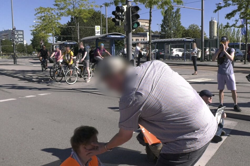 Ein Autofahrer ohrfeigt einen Aktivisten der "Letzten Generation" bei einer Straßenblockade in München.