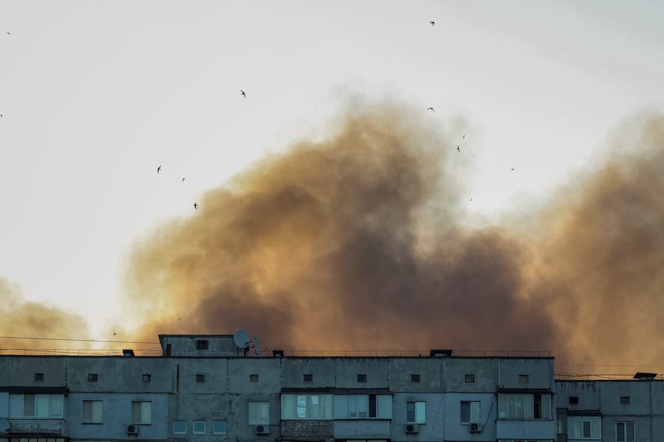 Birds fly over a residential building as smoke rises from the city after a Russian drone and missile strike in Kyiv, Ukraine, on July 4, 2025.