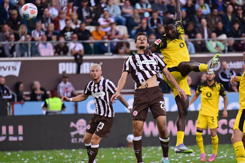 Serhou Guirassy (r) setzt sich gegen Adam Dzwigala durch und köpft zur BVB-Führung ein.