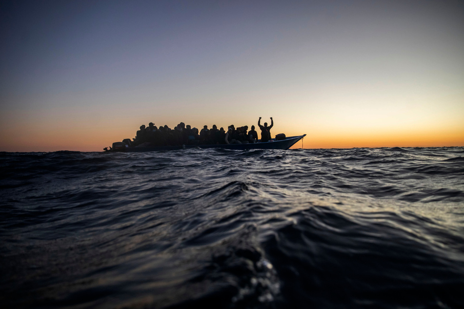 Migranten aus verschiedenen afrikanischen Nationen warten in einem Boot auf Helfer der spanischen NGO Open Arms, die sich ihnen 122 Meilen (ca. 196 km) vor der libyschen Küste im Mittelmeer nähern.