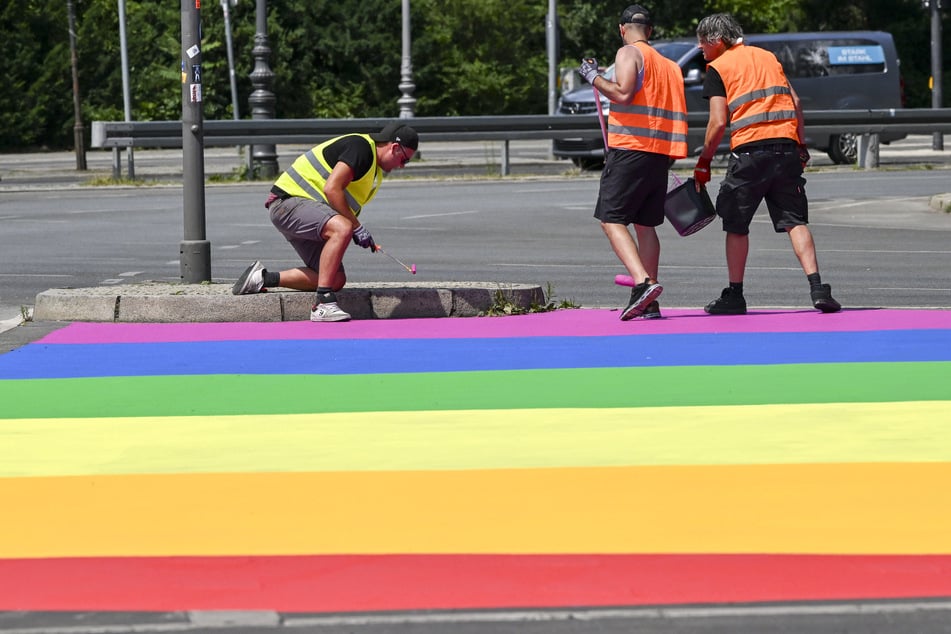 Auf einzelne Bereiche des Straßenbelags um die Berliner Siegessäule herum wird im Vorlauf zur diesjährigen CSD-Demonstration nach und nach die progressive Pride-Flagge gemalt.