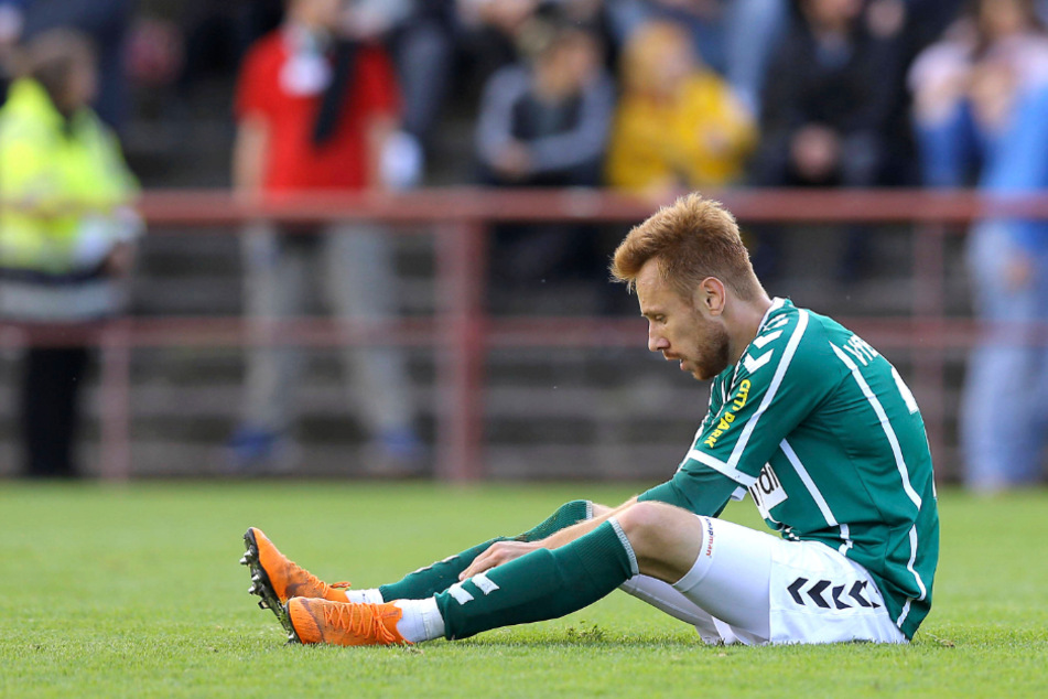 Der 27-jährige Dennis Hoins sitzt erschöpft auf dem Spielfeld.