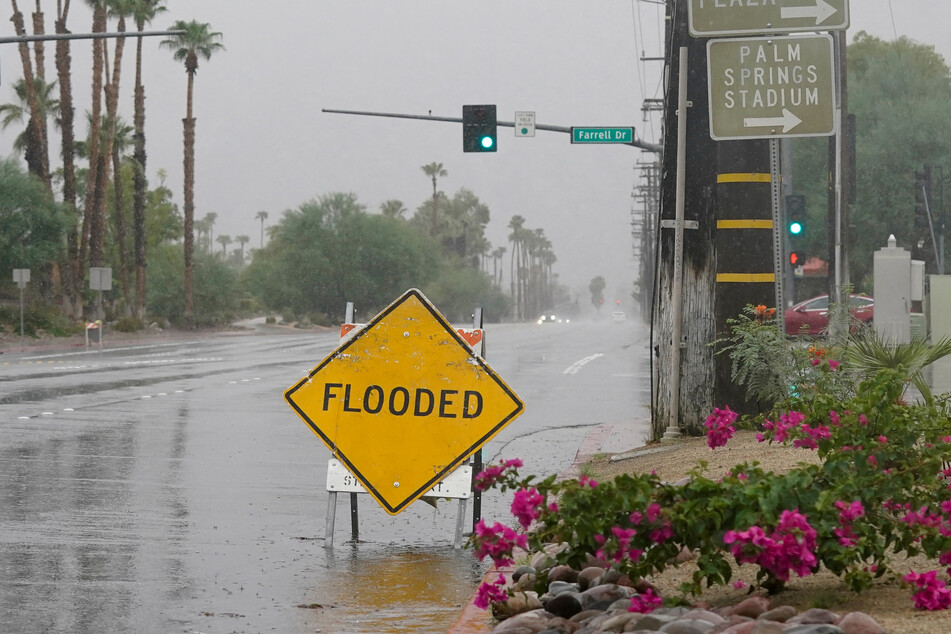 A sign warns of flooded roads as Tropical Storm Hilary approaches Palm Springs, California.