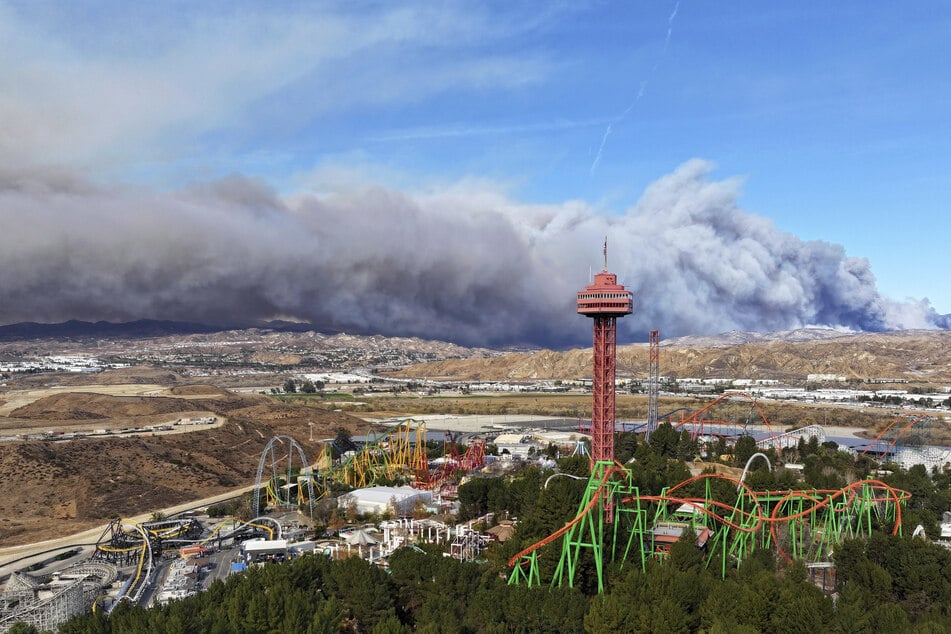 Der Turm des Freizeitparks Six Flags Magic Mountain mit dem brennenden Hughes-Feuer im Hintergrund.